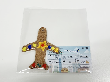 反射材を使って完成したオリジナルキーホルダーと障がいのある社員がデザインした搭乗券をイメージしたメッセージカード